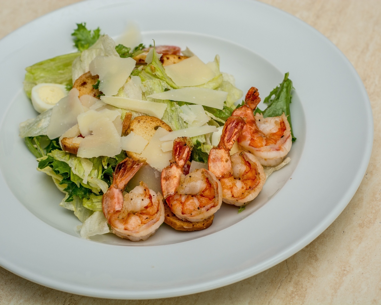Креветки на тарелке с листьями салата