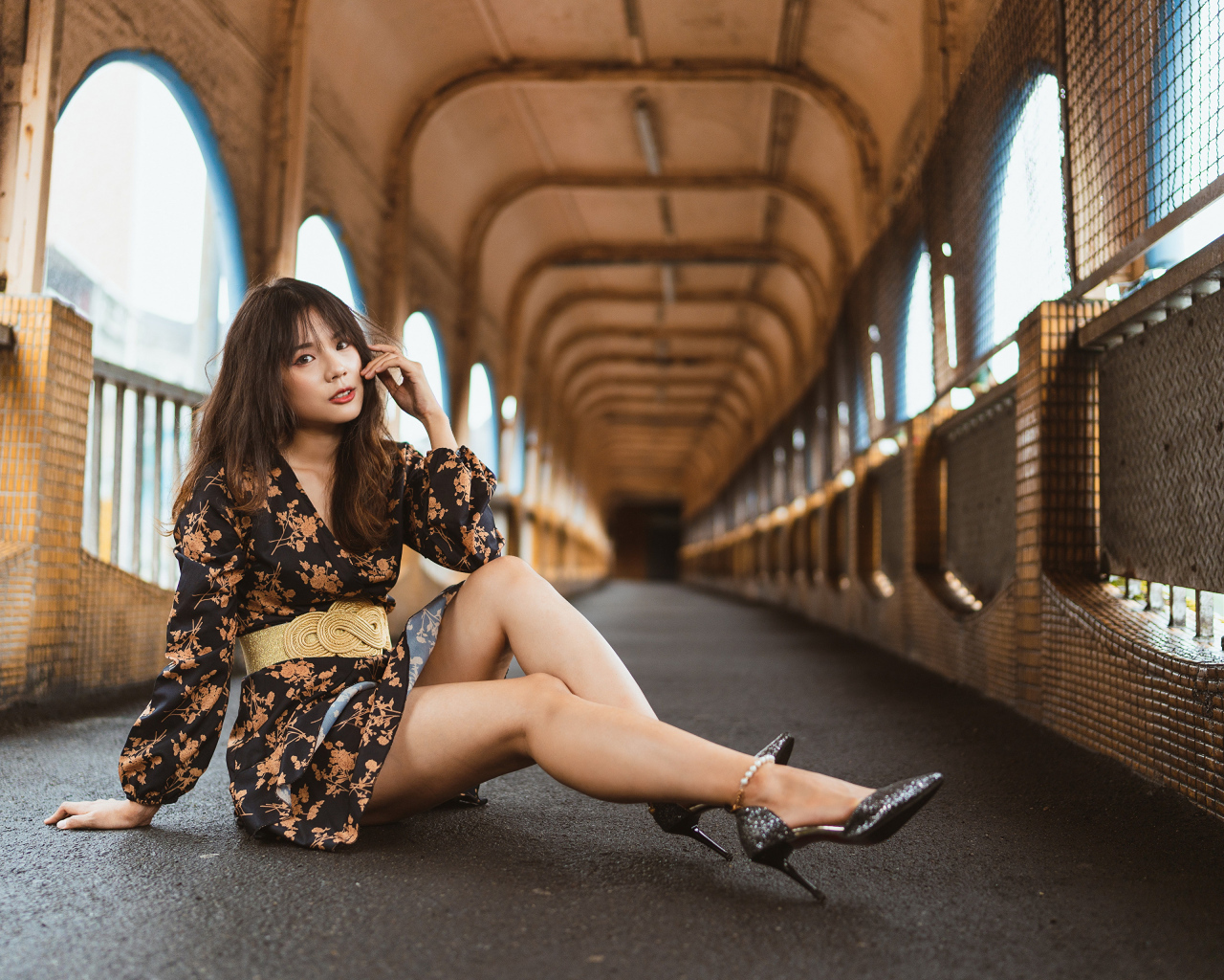 Девушка в красивом коротком платье сидит на полу