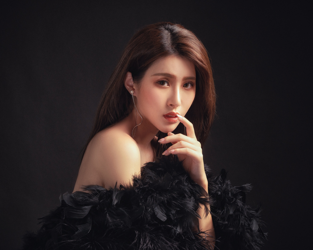 Девушка азиатка в боа на черном фоне