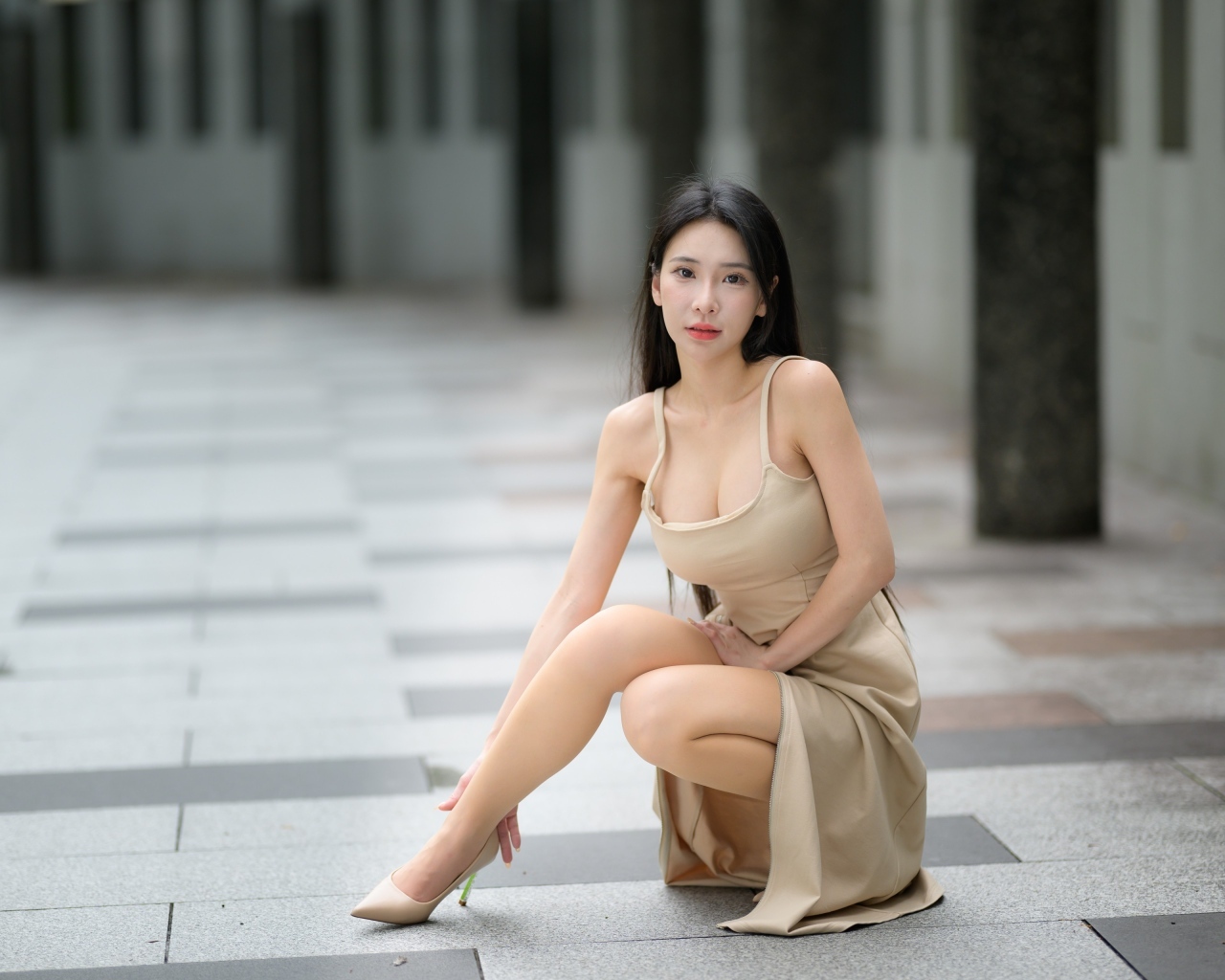 Девушка азиатка в платье сидит на корточках