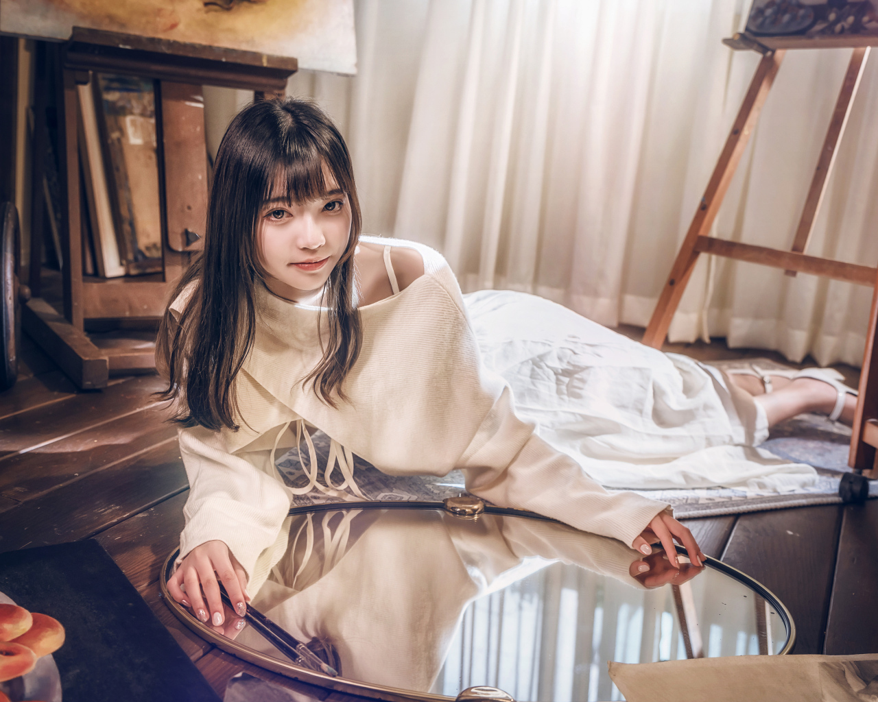 Девушка азиатка в белом платье лежит на полу