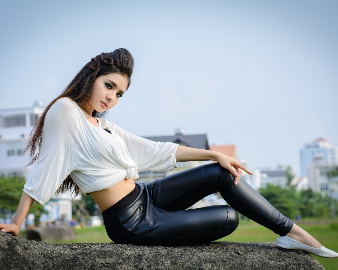 Девушка азиатка в черных кожаных брюках