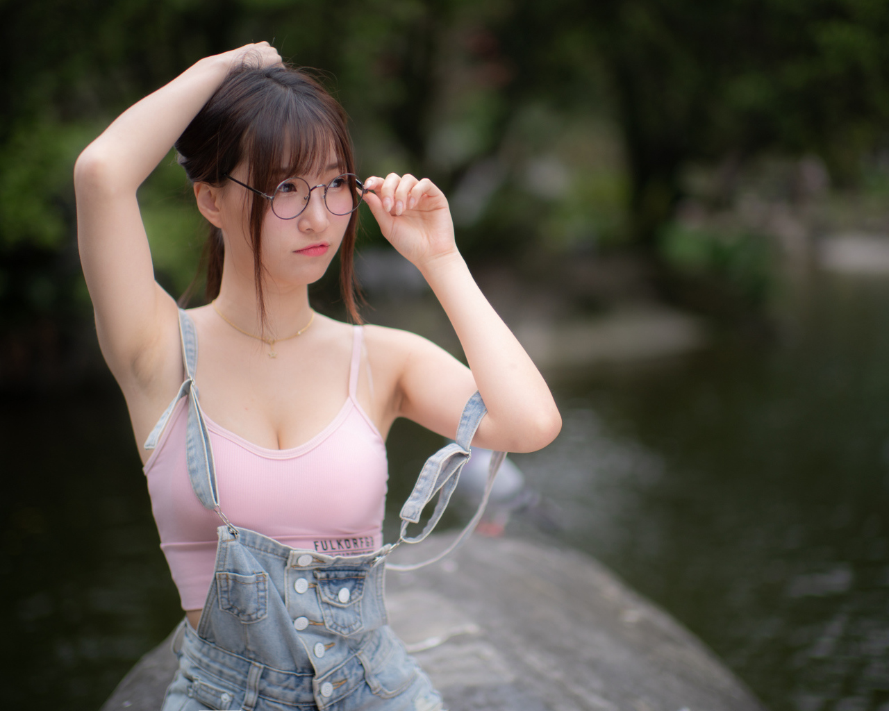 Девушка азиатка в очках и джинсовом комбинезоне