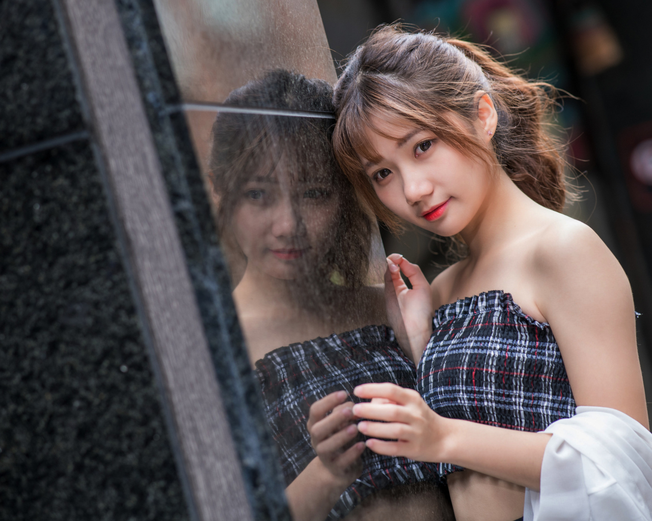 Девушка азиатка отражается в стене