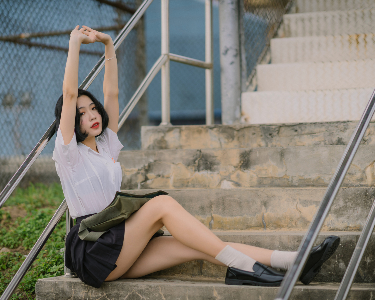Девушка азиатка потягивается на ступеньках