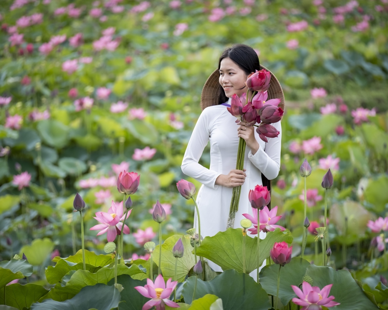 Девушка азиатка с розовыми цветами лотоса в руках