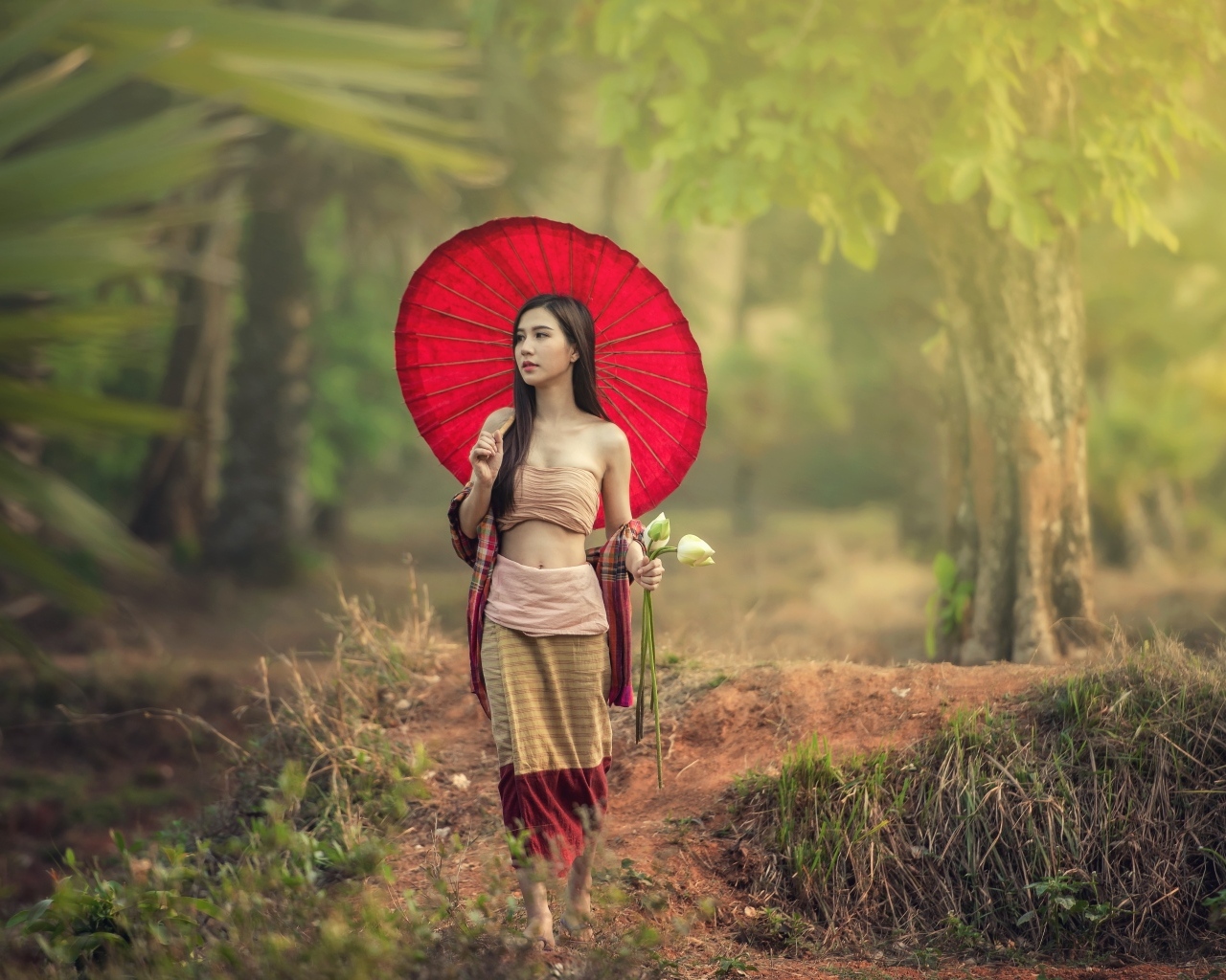 Девушка азиатка с красным зонтом и цветами лотоса