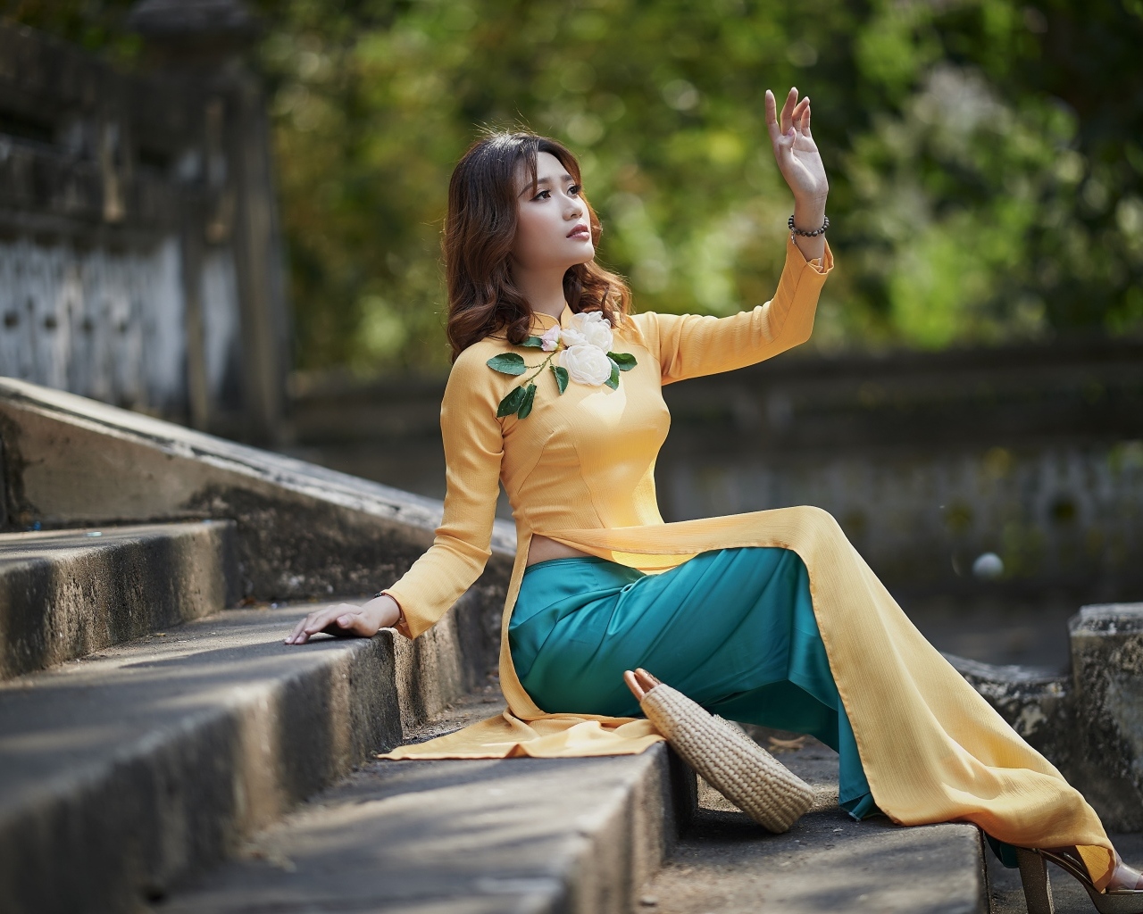 Красивая девушка азиатка сидит на ступеньках