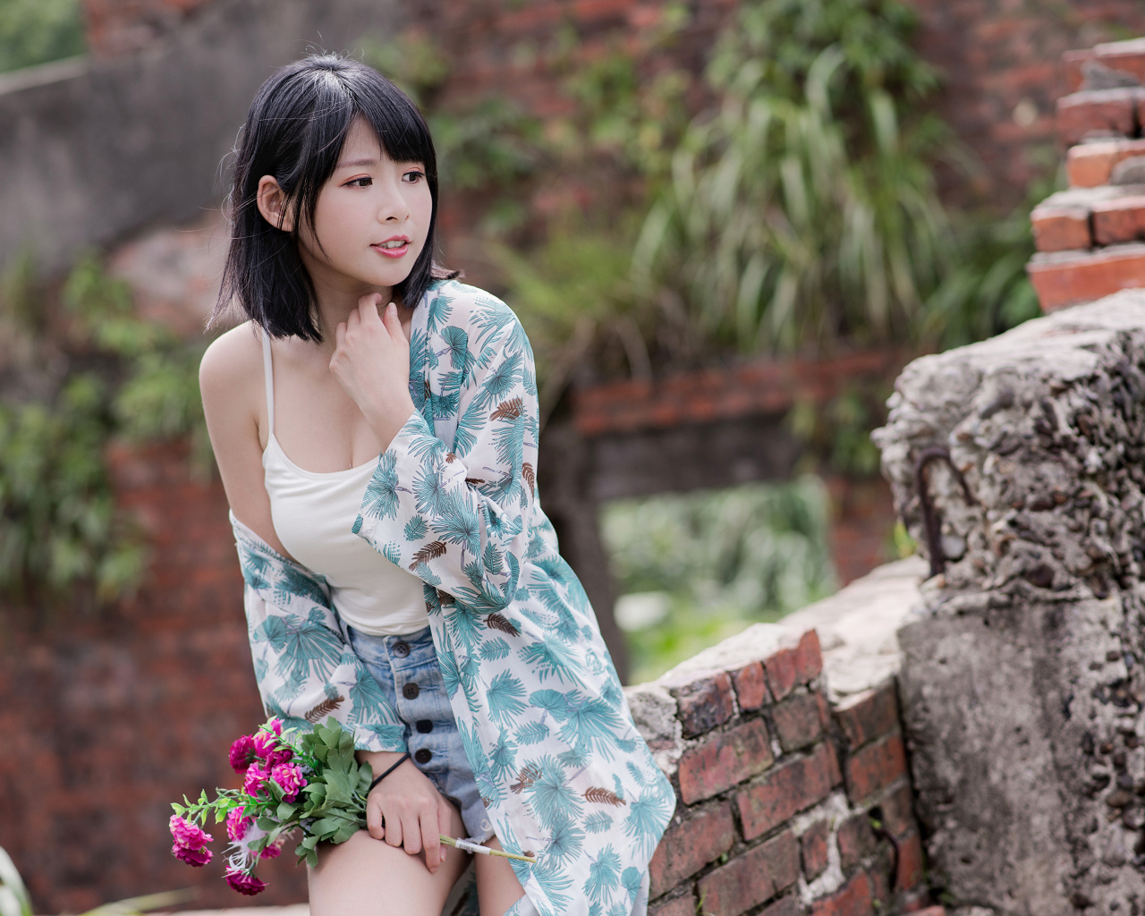 Красивая азиатка с цветком в руке