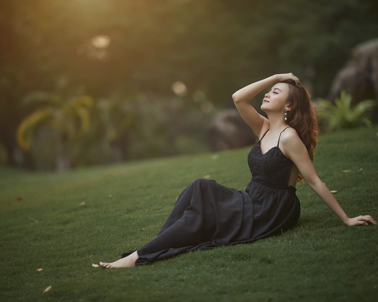 Красивая азиатка с закрытыми глазами в черном платье