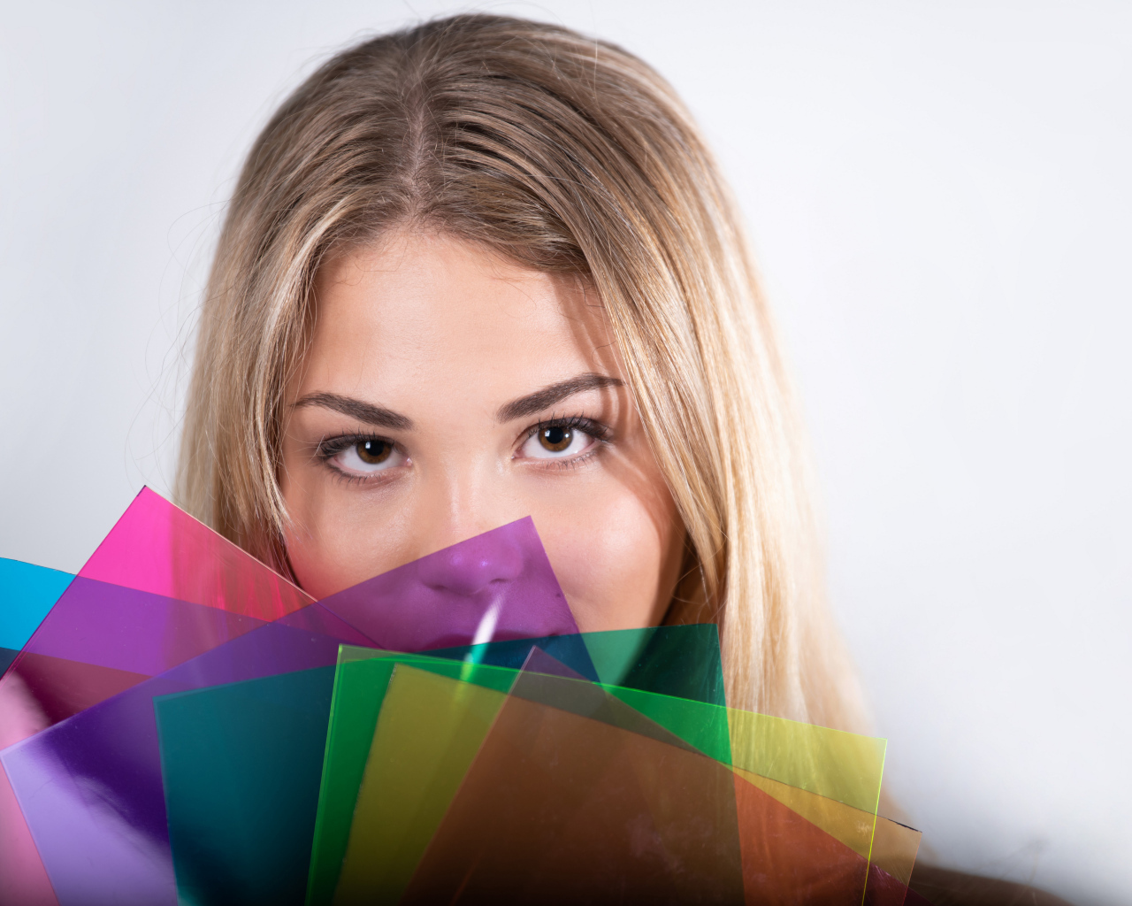 Красивая кареглазая девушка с разноцветной бумагой