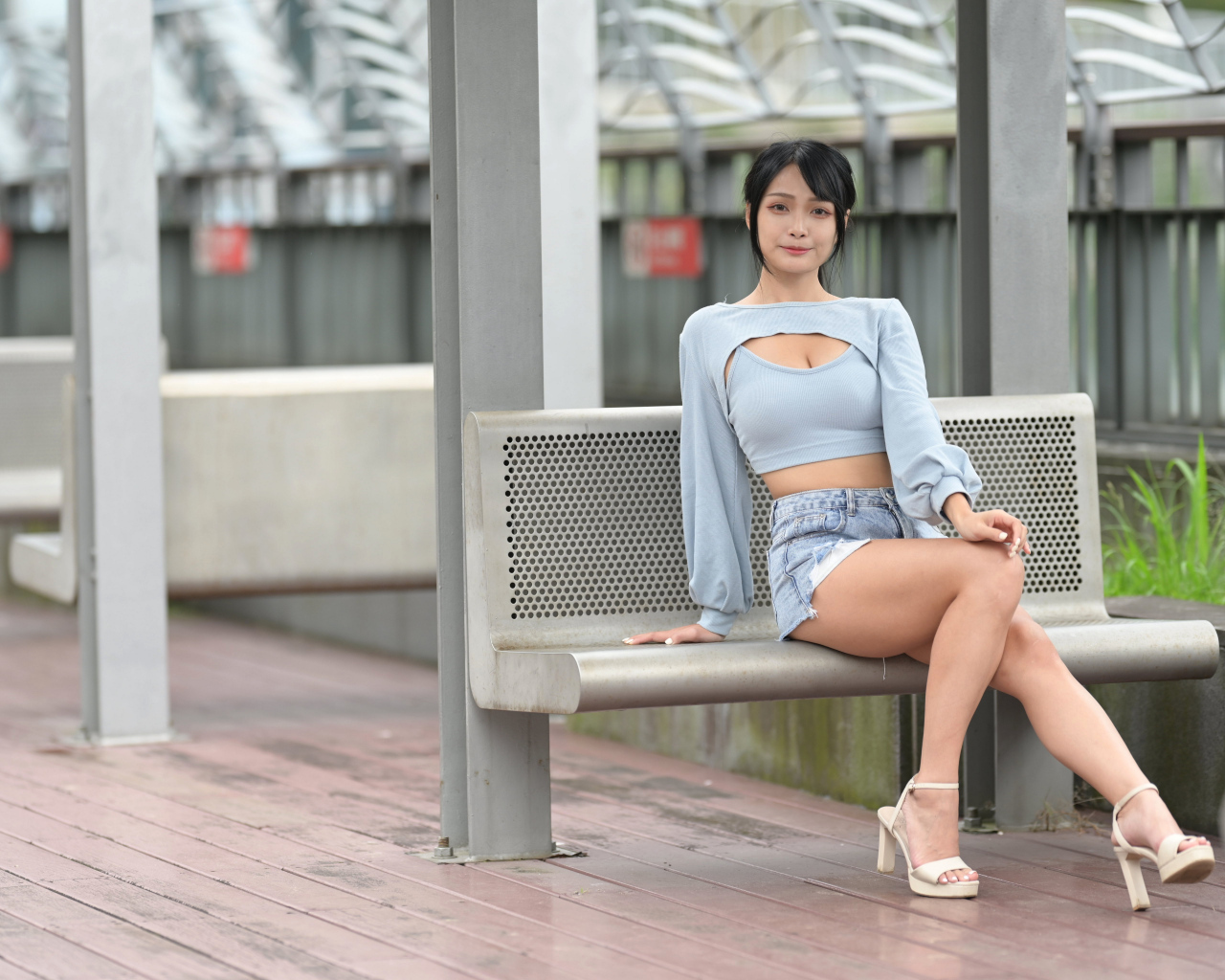 Красивая темноволосая девушка азиатка сидит на лавке