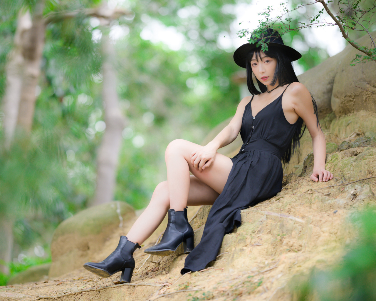 Красивая девушка в черном платье и шляпе