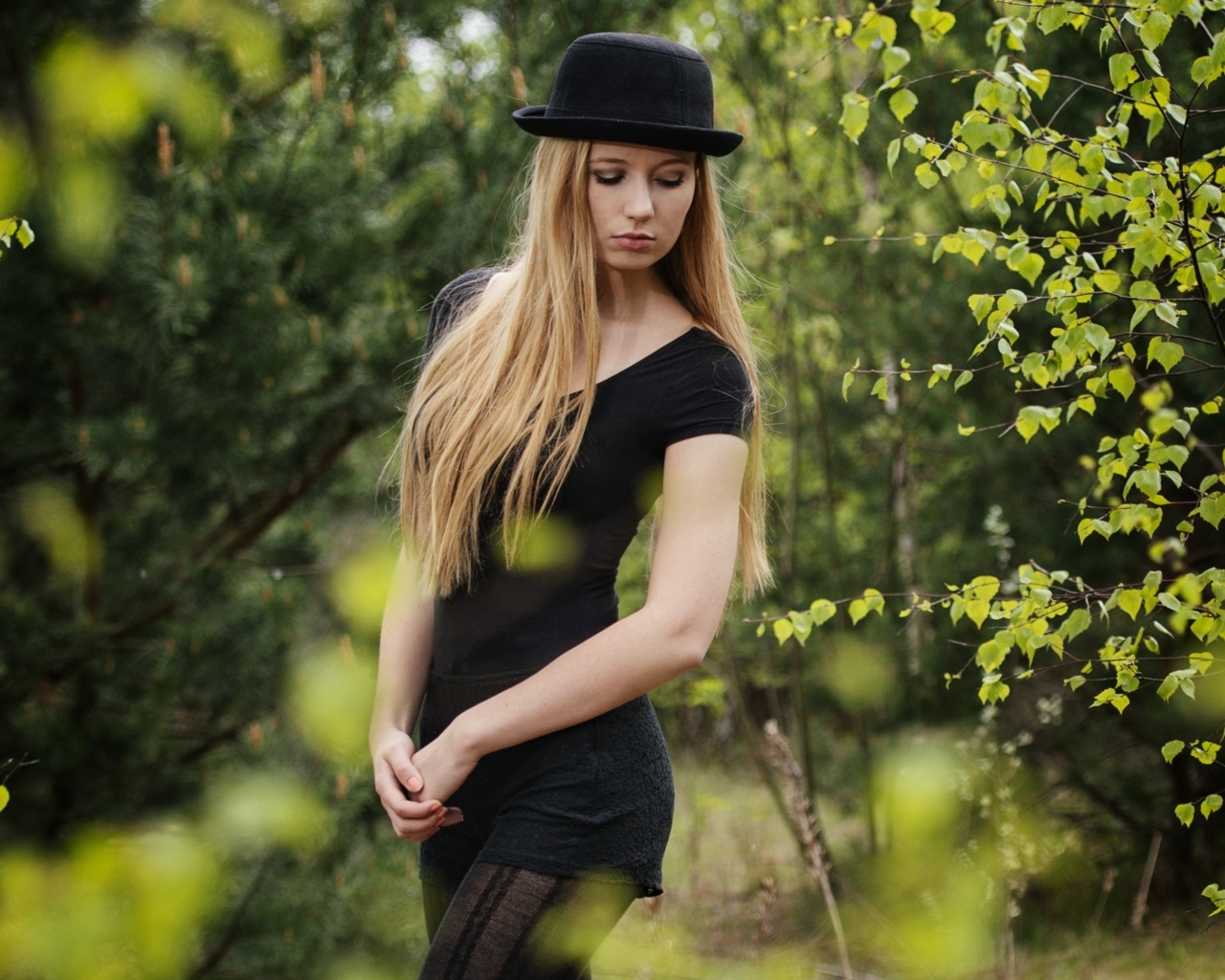 Красивая девушка в черном наряде в шляпе