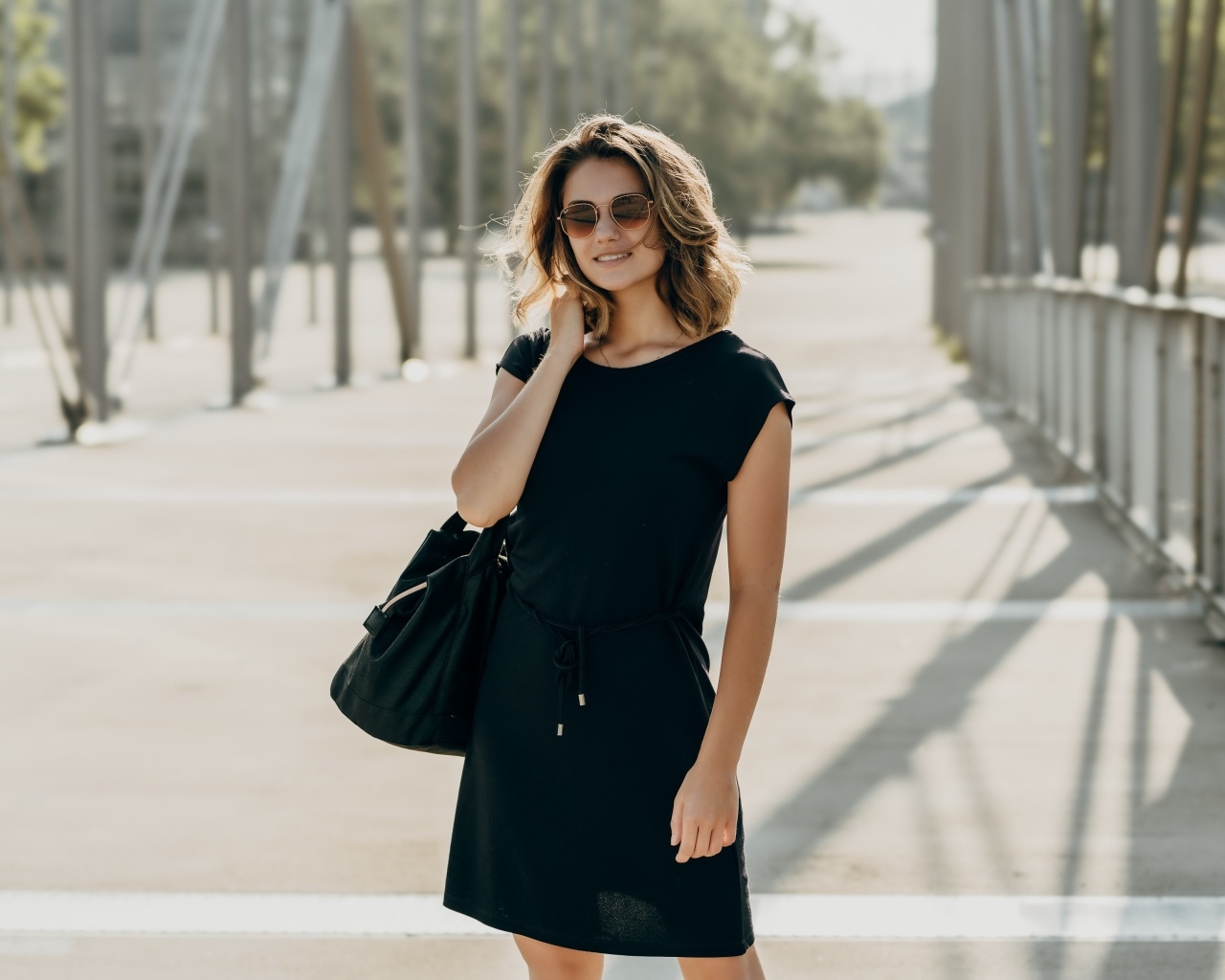 Красивая девушка в черном платье в очках