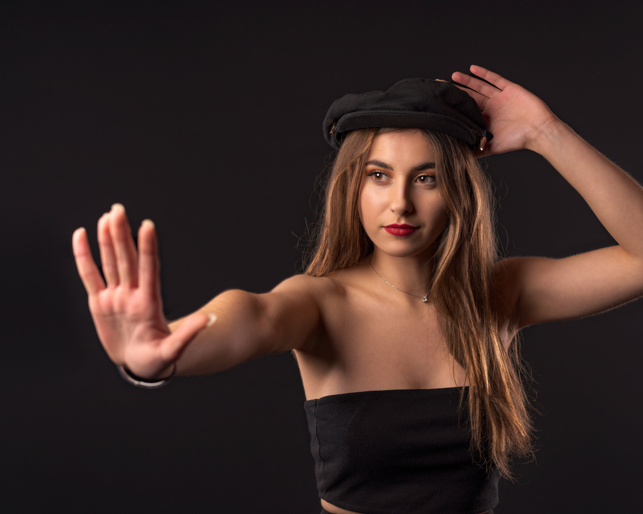 Красивая девушка в кепке на черном фоне