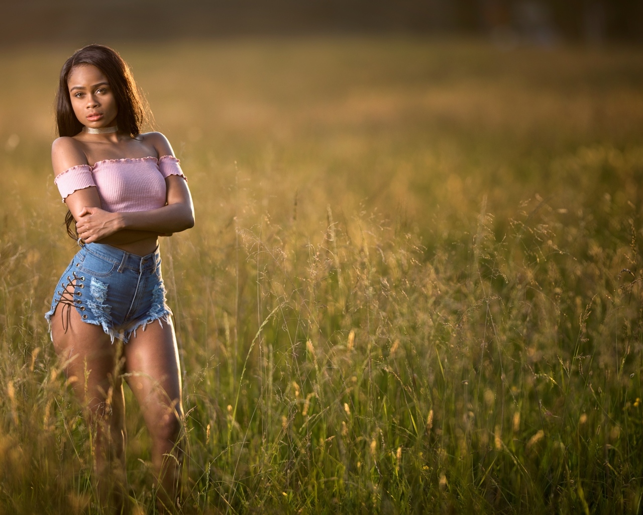 Красивая девушка стоит на поле в траве