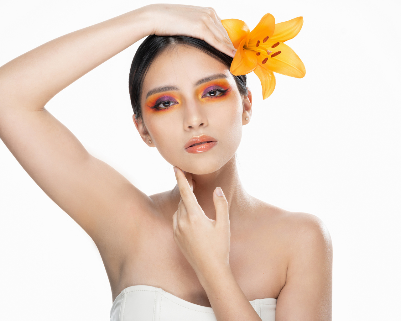 Красивая девушка с цветком лилии в волосах на белом фоне