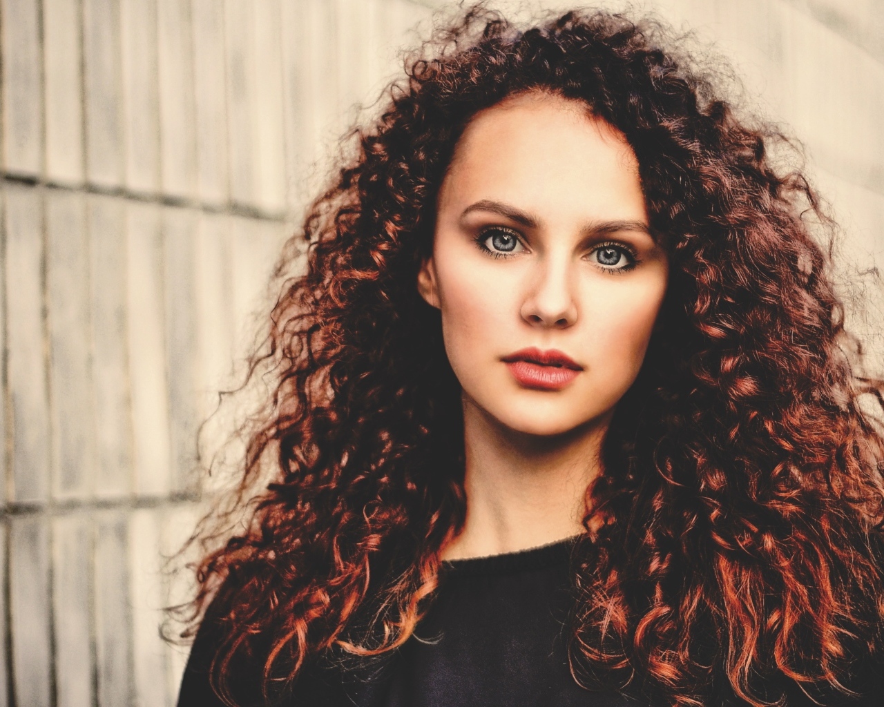 Кудрявые красивые волосы у девушки с серыми глазами