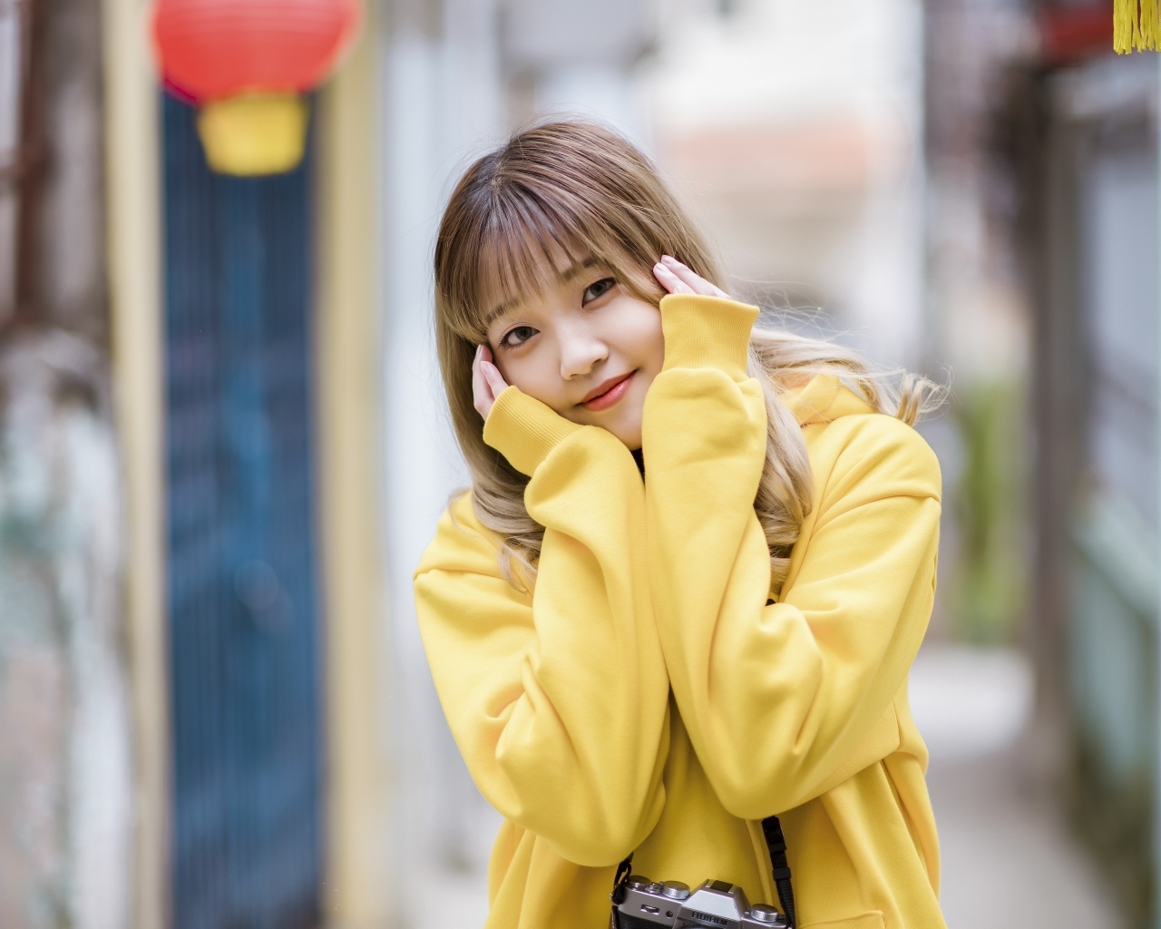 Милая девушка азиатка в желтом свитере
