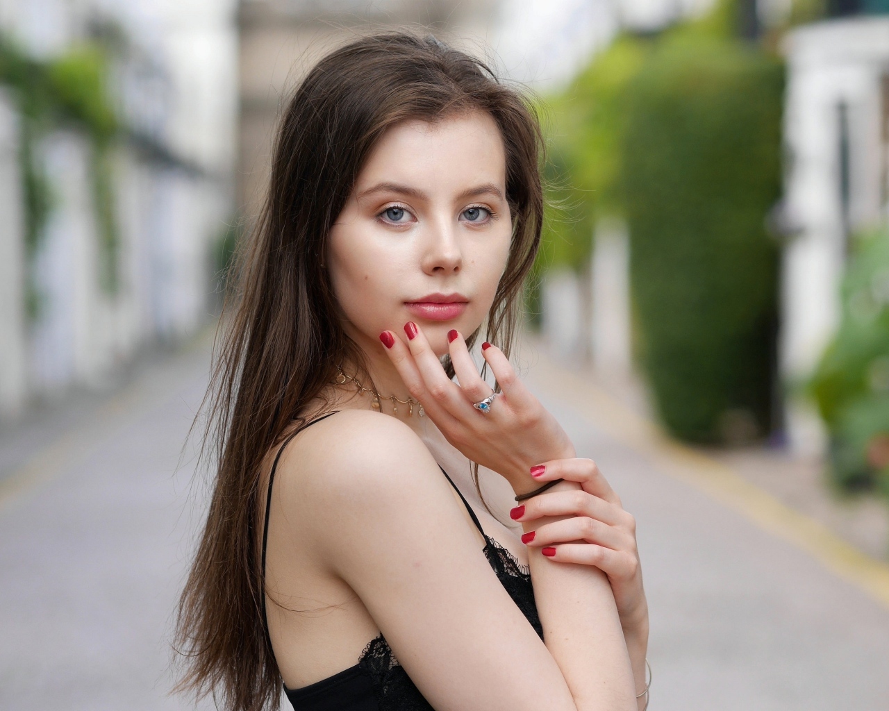 Милая голубоглазая девушка с красным маникюром