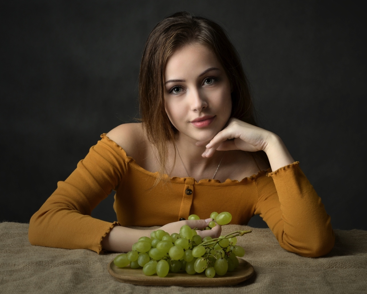 Милая шатенка ест белый виноград
