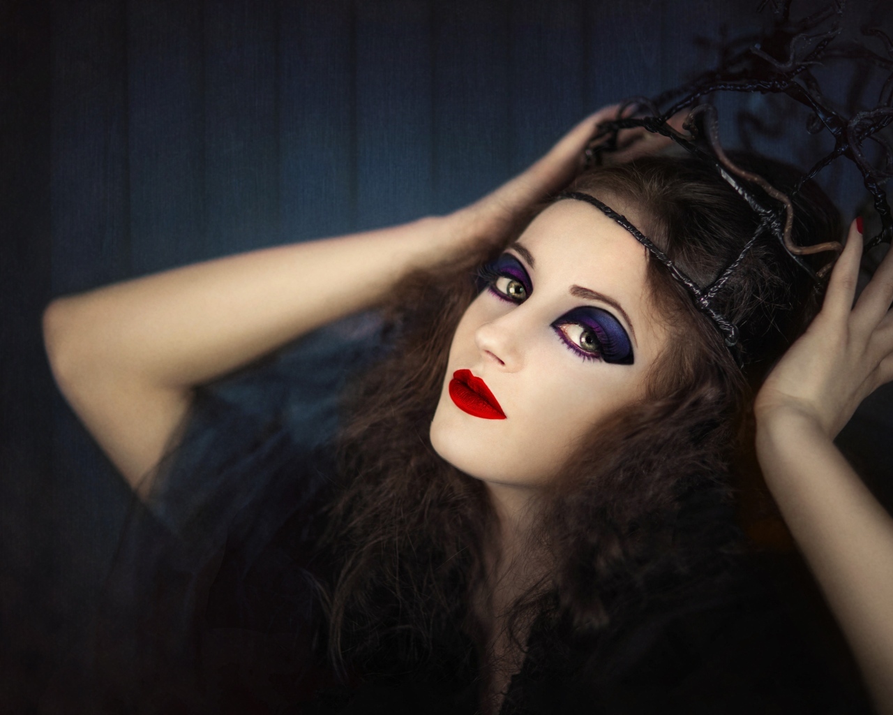 Девушка в черном наряде с ярким макияжем