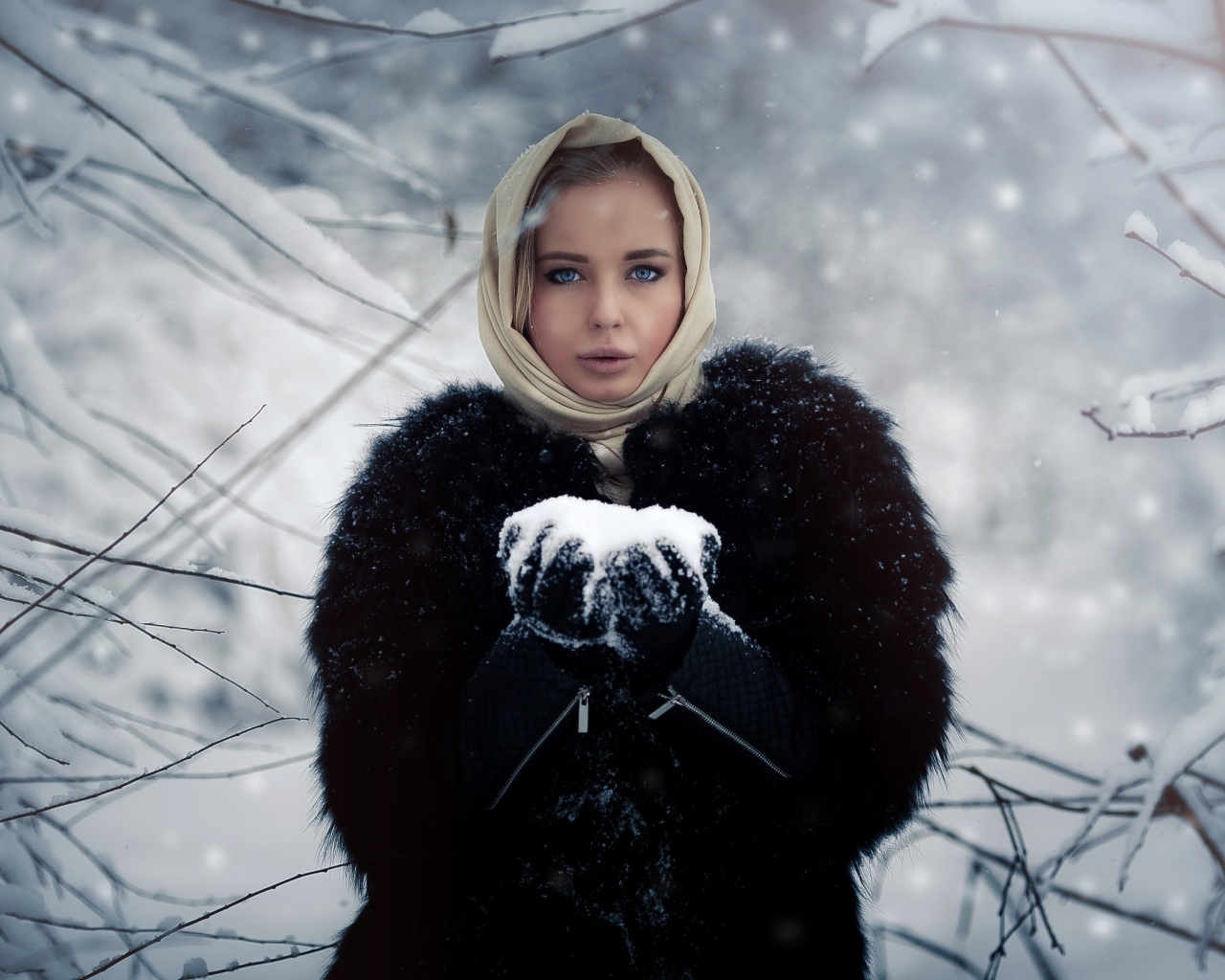 Девушка в черной шубе в заснеженном лесу