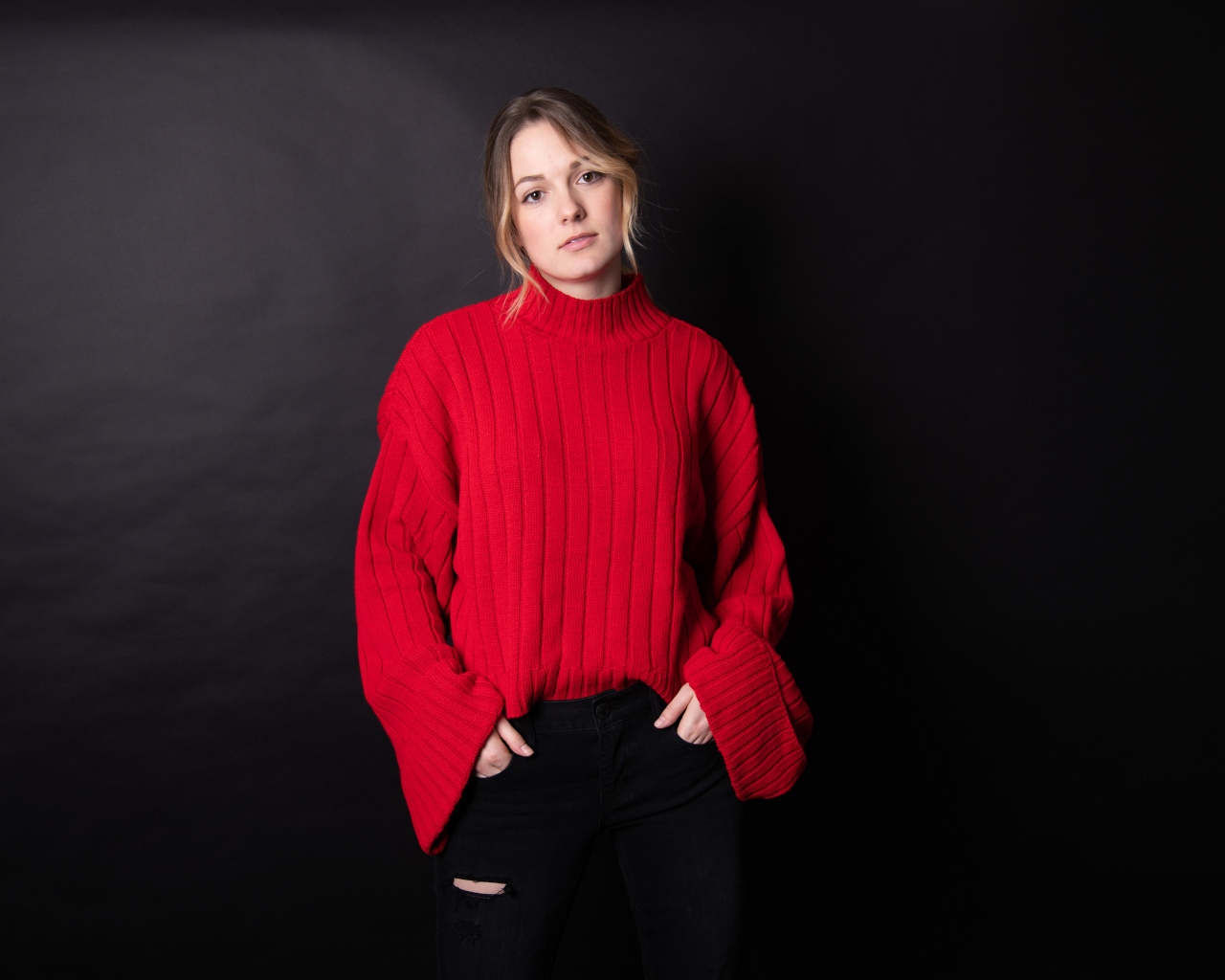 Девушка в красном свитере на черном фоне