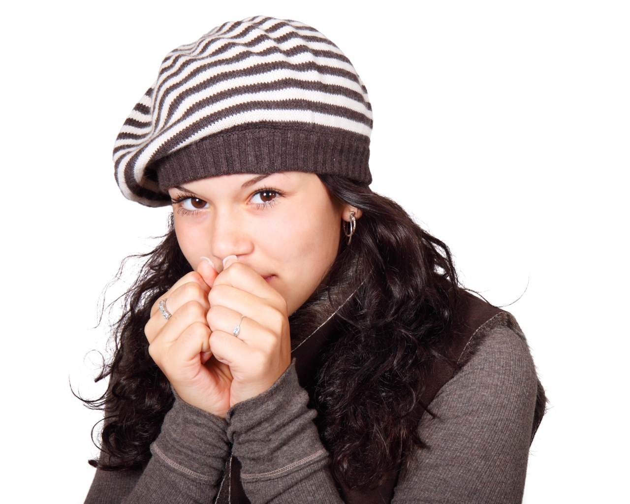 Девушка в теплой полосатой шапке на белом фоне