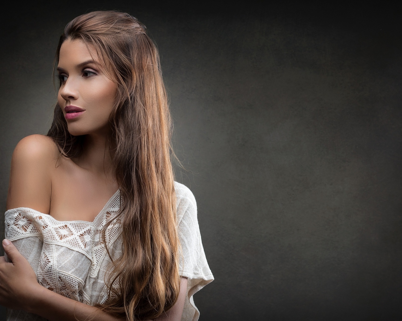 Девушка в белом платье с длинными волосами на сером фоне