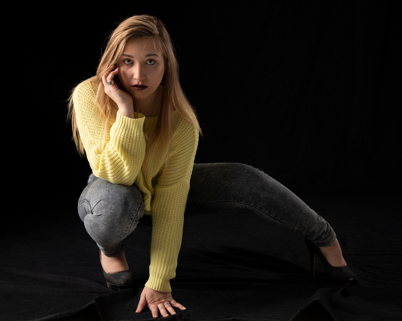 Девушка в желтом свитере на черном фоне