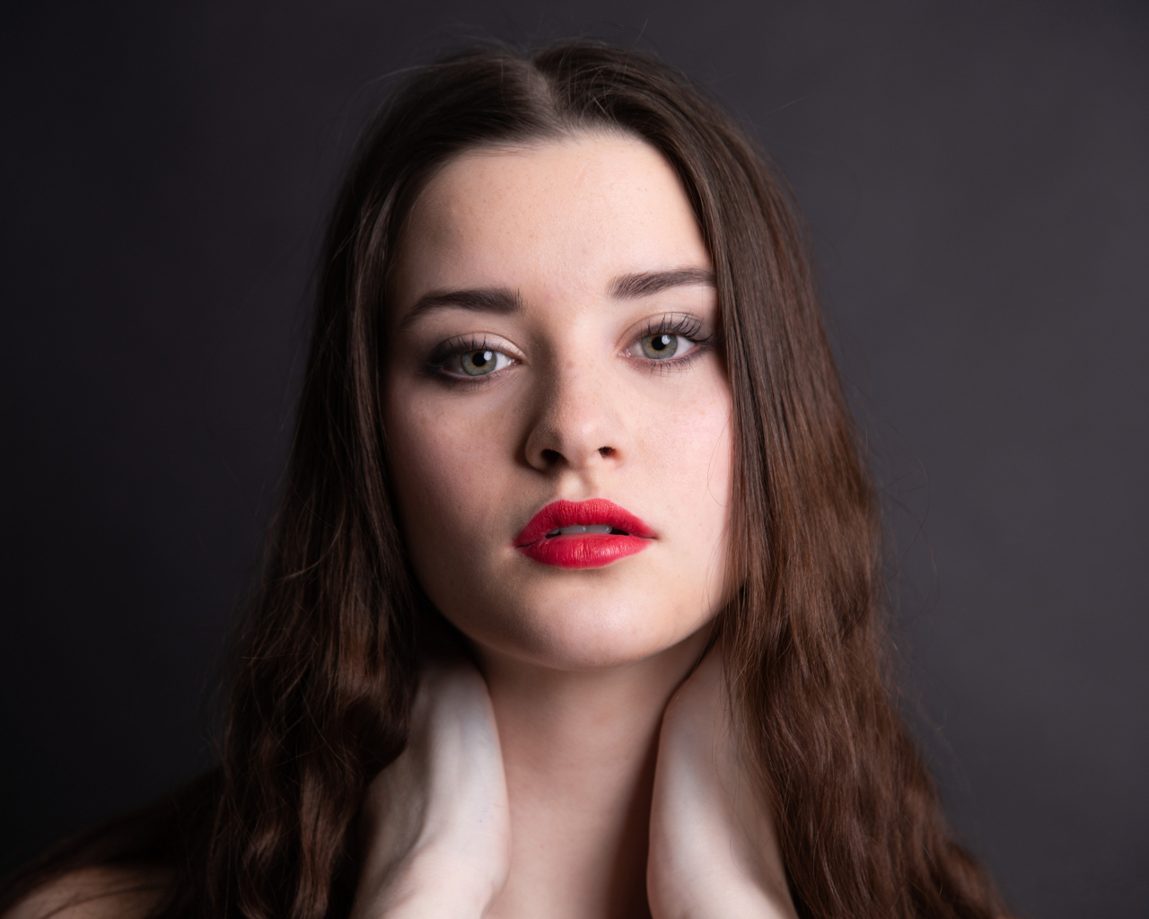 Девушка с красными губами на сером фоне