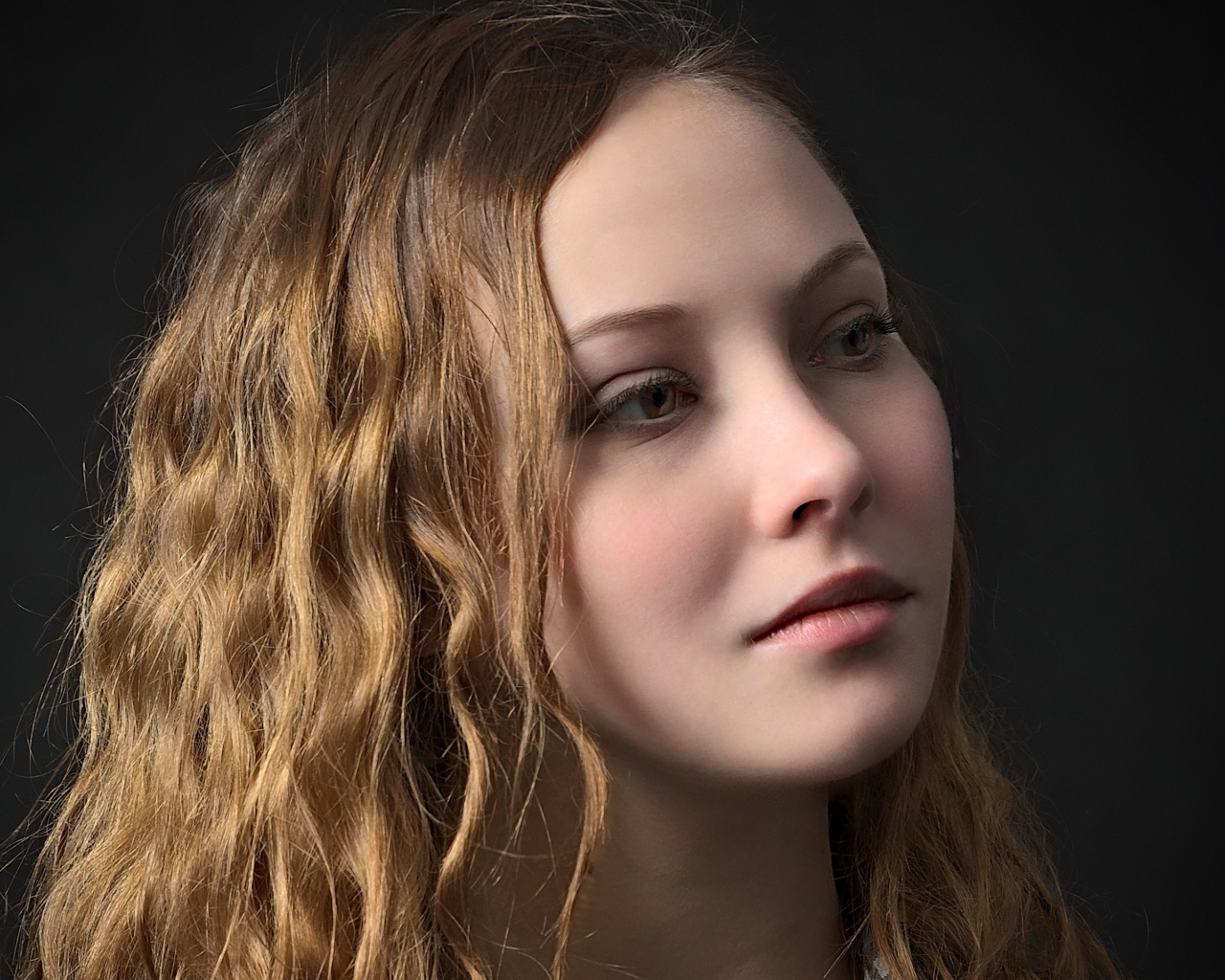 Длинноволосая кареглазая девушка на черном фоне