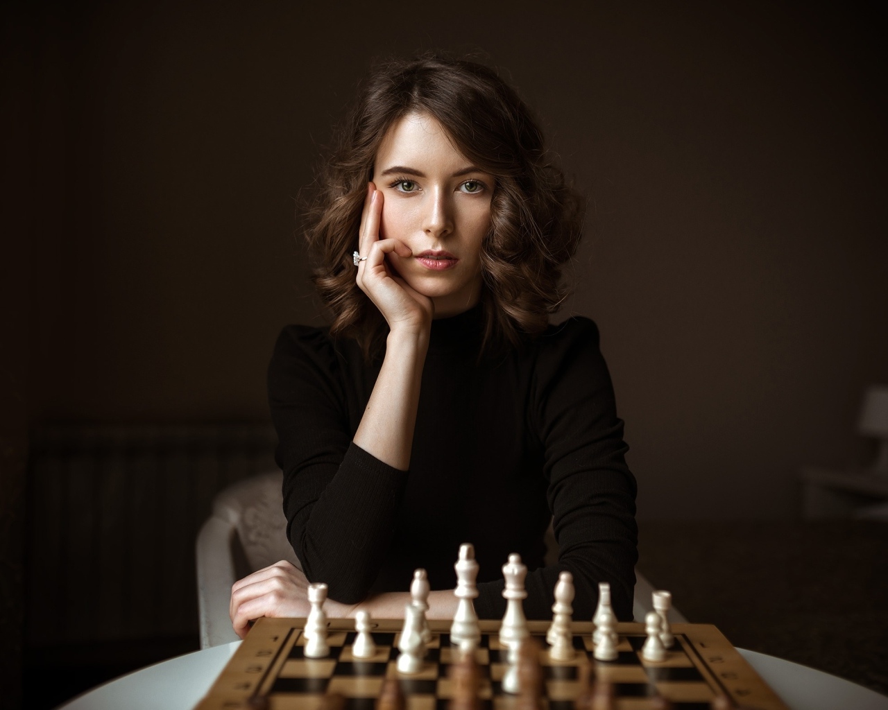 Умная молодая девушка играет в шахматы