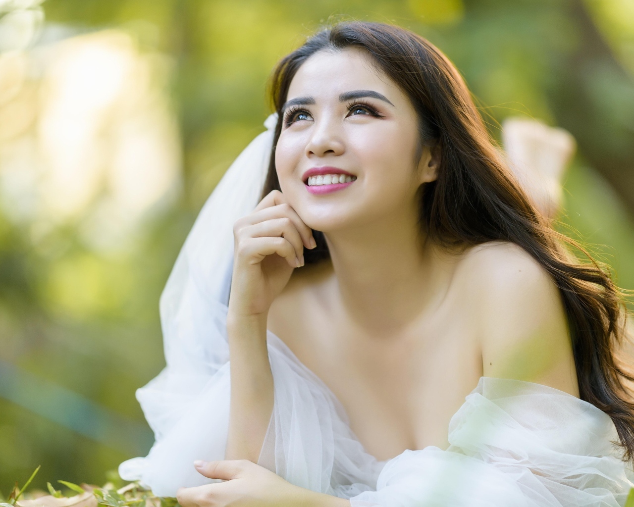 Улыбающаяся девушка азиатка в платье невесты