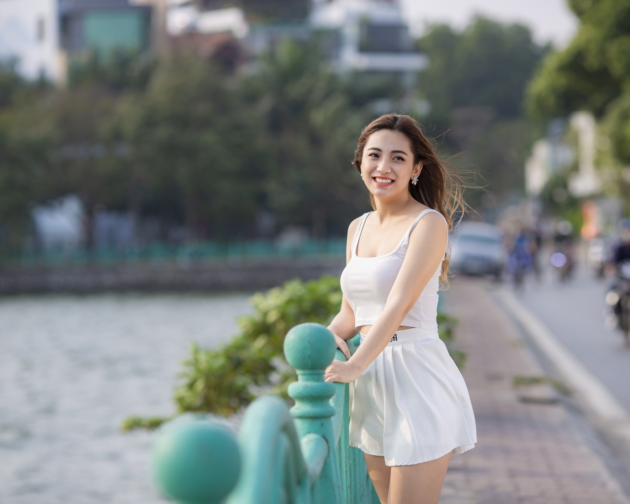 Улыбающаяся девушка азиатка в белом летнем костюме