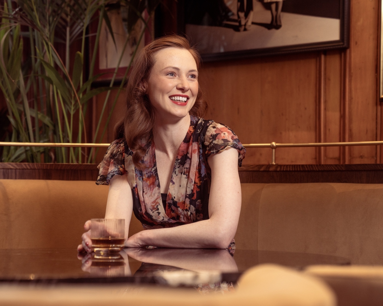 Улыбающаяся девушка за столиком в кафе