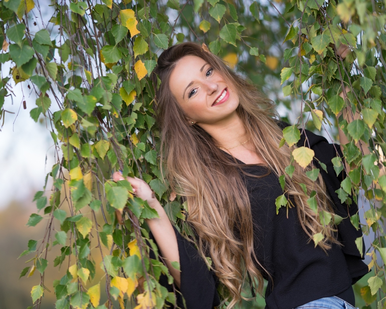 Улыбающаяся девушка в ветках березы