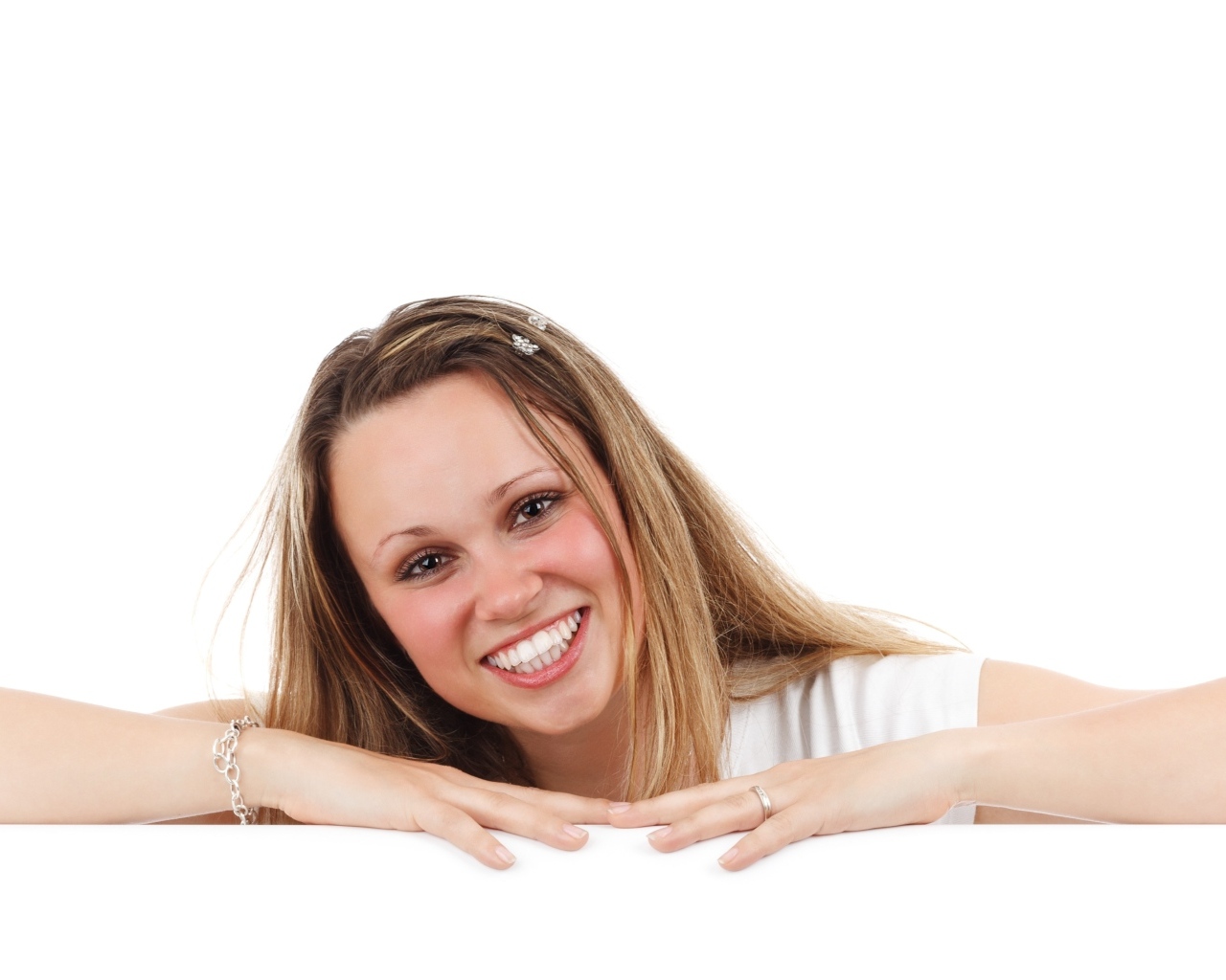 Улыбающаяся девушка сидит на белом фоне