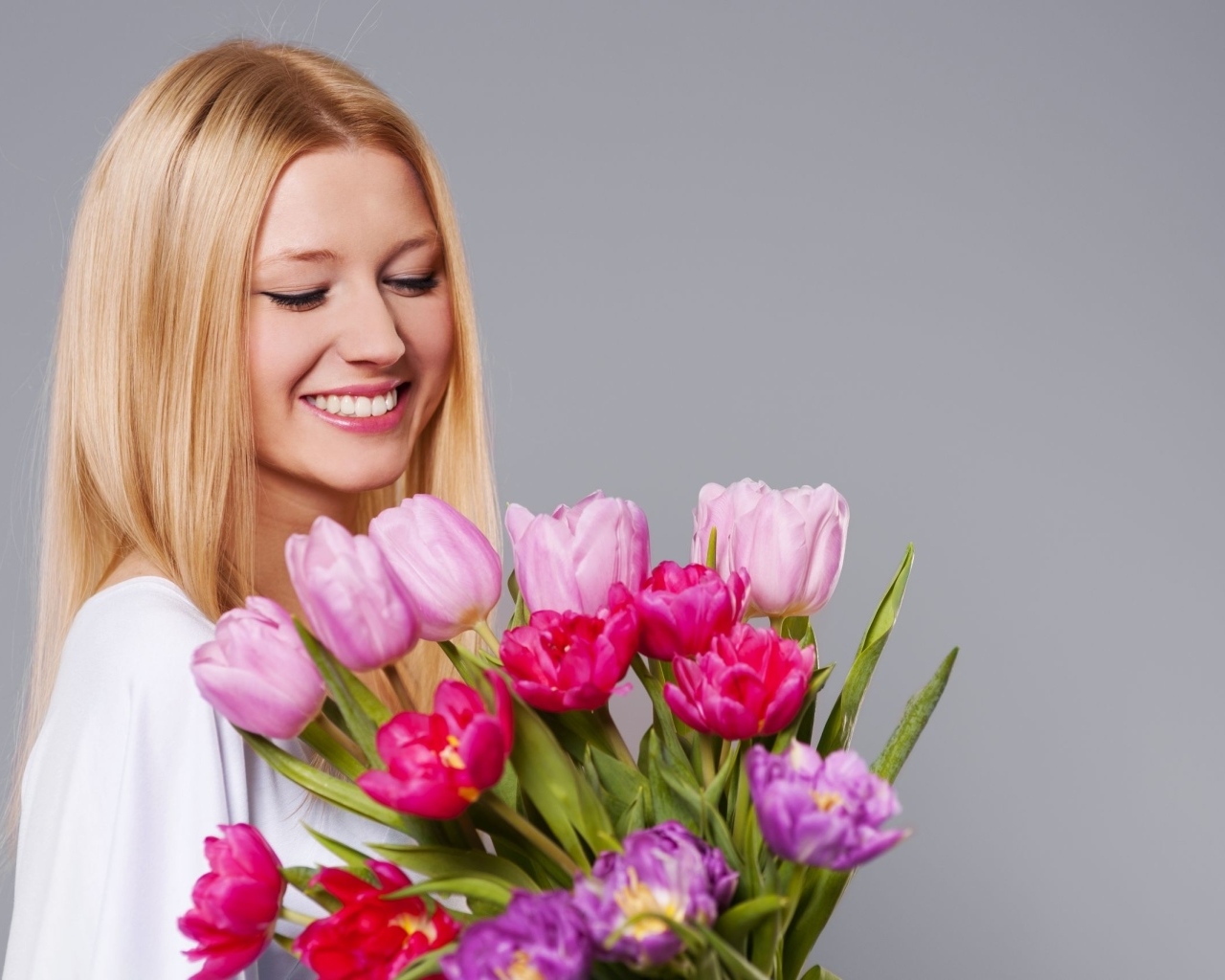Улыбающаяся девушка с букетом тюльпанов