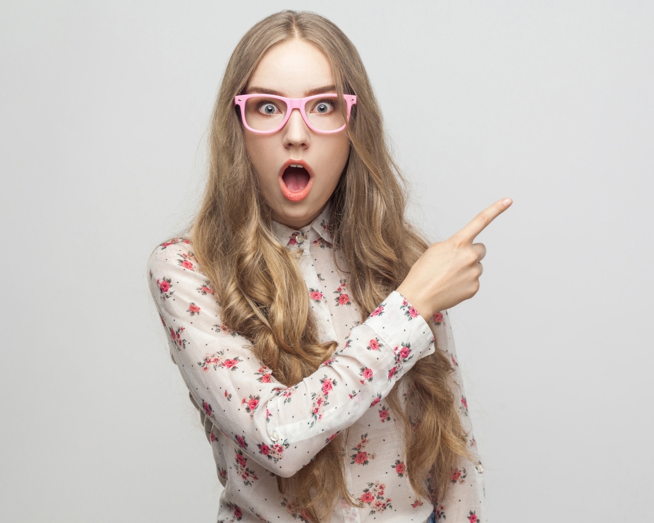 Удивленная девушка на сером фоне