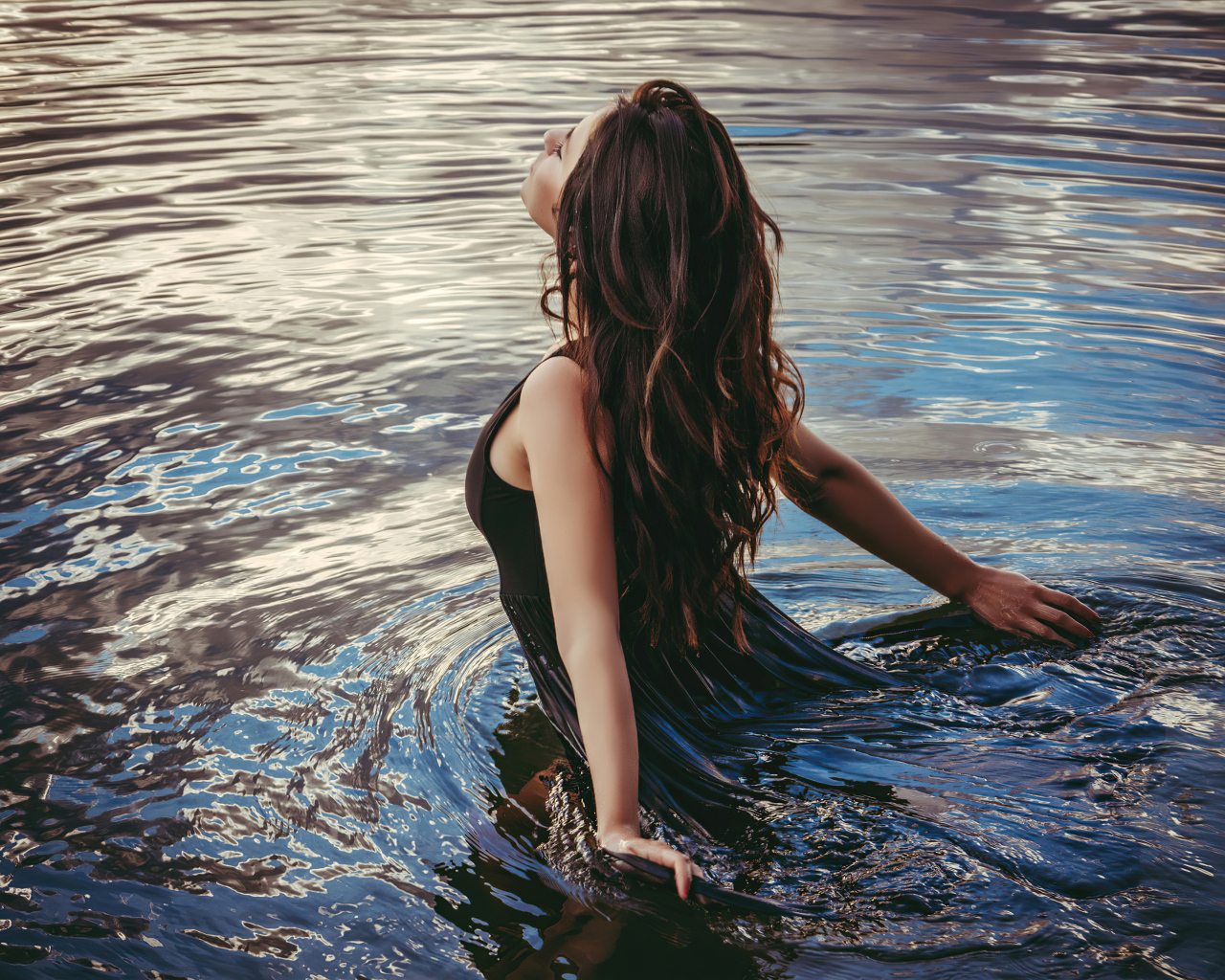 Молодая девушка купается в воде