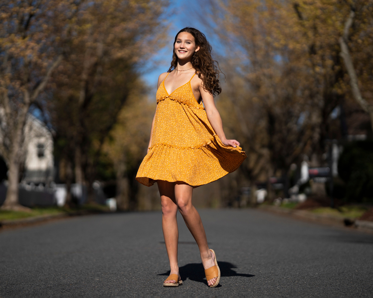 Молодая девушка в коротком платье на дороге  летом