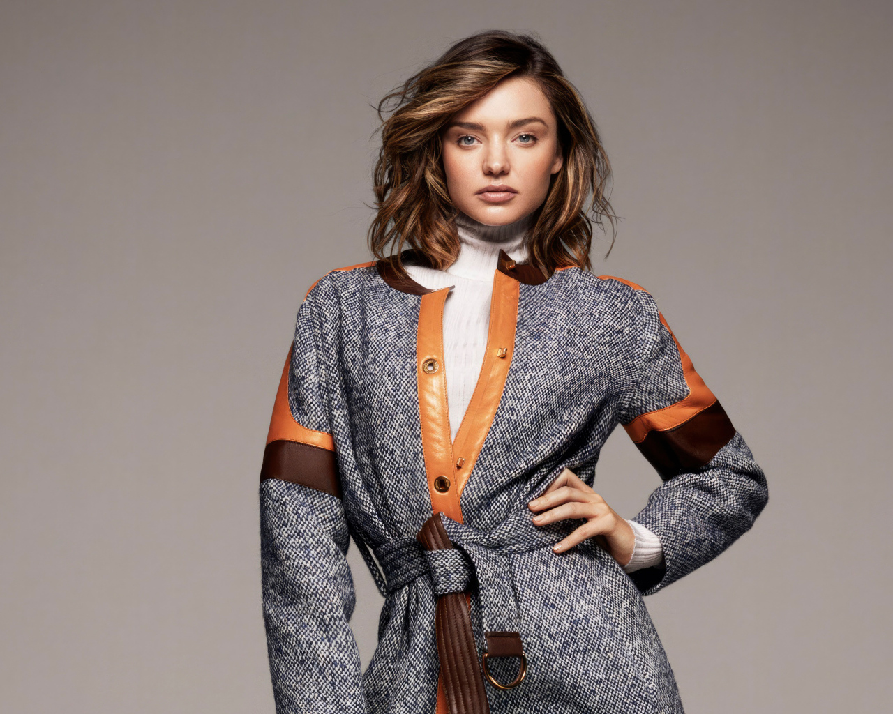 Стильная молодая модель Миранда Керр в пальто на сером фоне