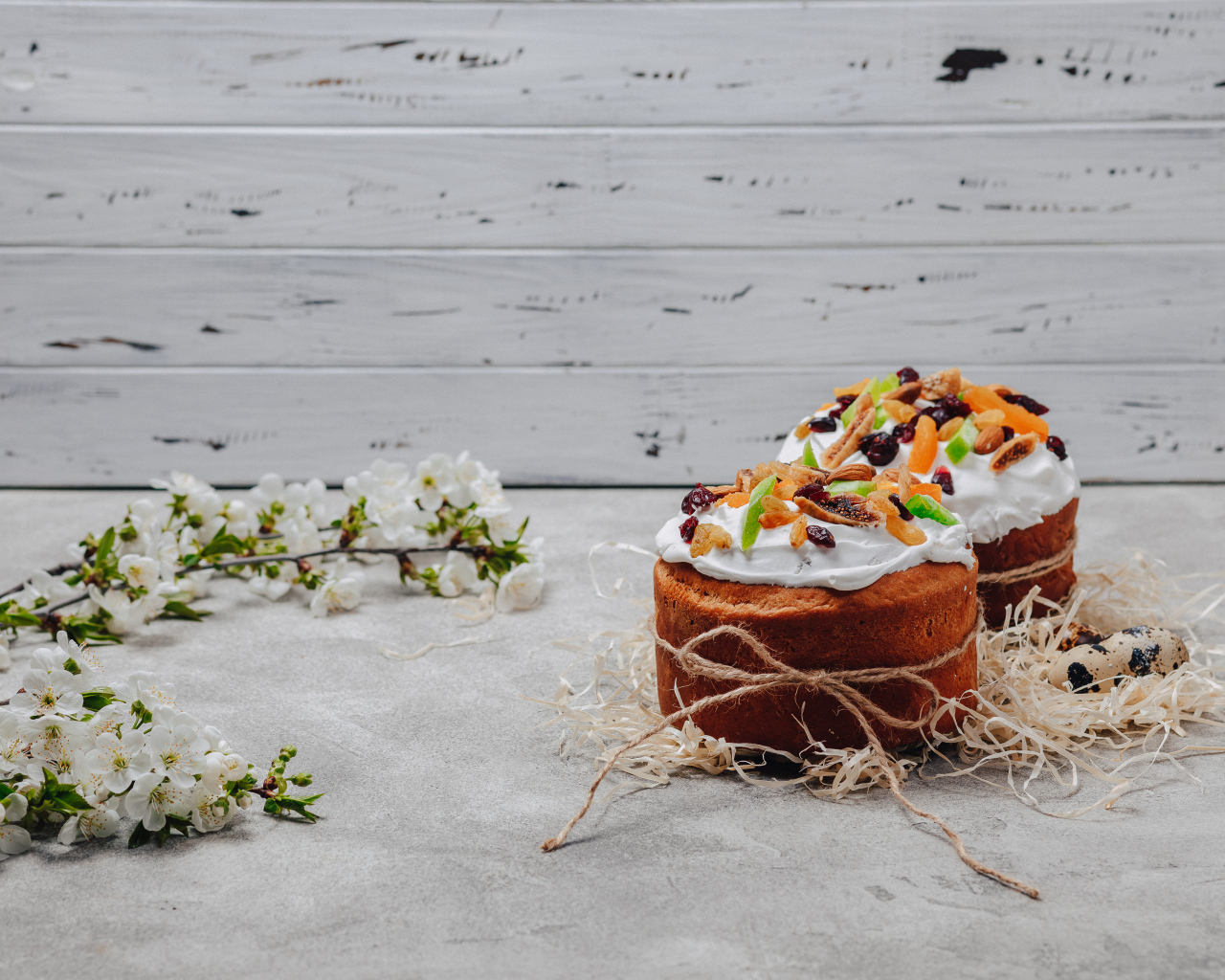 Красивые пасхальные куличи с веткой вишни на сером столе на Пасху