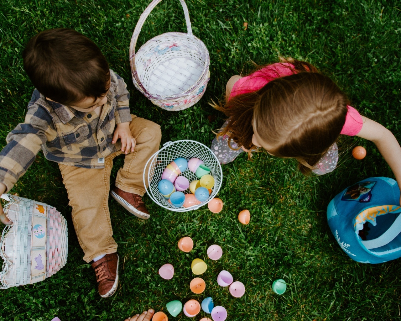 Дети играют на траве с пасхальными яйцами
