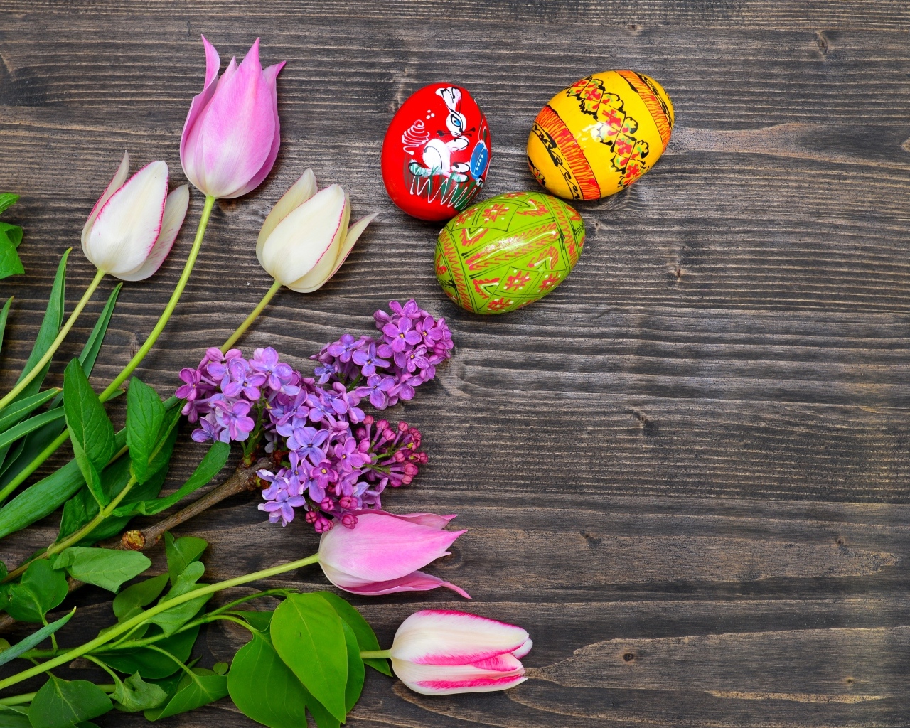 Пасхальные яйца с живыми цветами на столе 