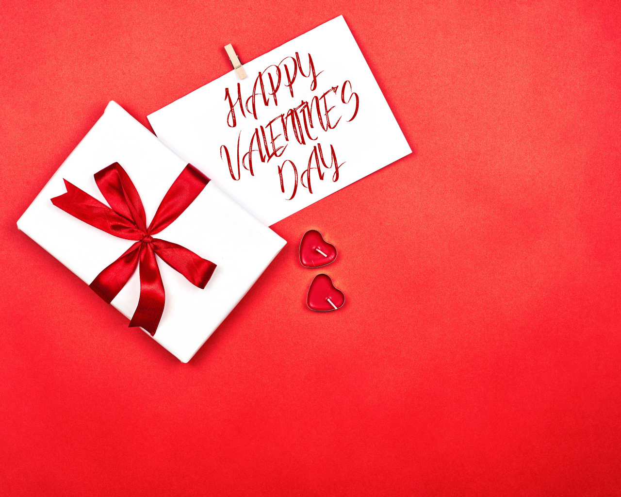 Открытка и подарок на красном фоне на День Святого Валентина