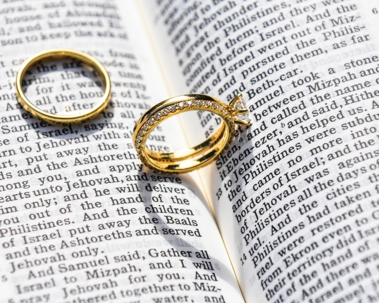 Два золотых обручальных кольца лежат на газете